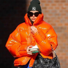 Dua Lipa bright orange puffer jacket